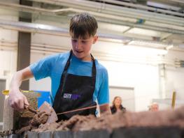 A pupil practices bricklaying  