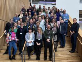Group shot of attendees of the Network of Networks event standing on the stairs at our Riverside Campus. 