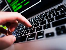 Close up image of laptop key with fingers typing. 