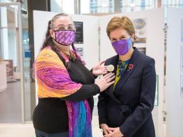 Photo of Jewellery student Aileen Dickie-Adams presenting First Minister with COP26 Climate Brooch 