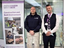 Apprentice Jaemie Smith with Andy McNicol standing next to pop up banner in college  