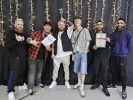 Barbering students pose with their certificates and trophy. 