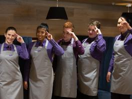 Hospitality students standing in a row at Scholars restaurant. 