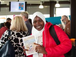 Student poses with city of poems book 
