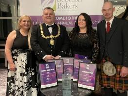 Lisa Ross and Jason Ross (Bakery Lecturers), Sharon Ross (City Market) and Alastair McAusland (Baker) standing at a table with their awards. 