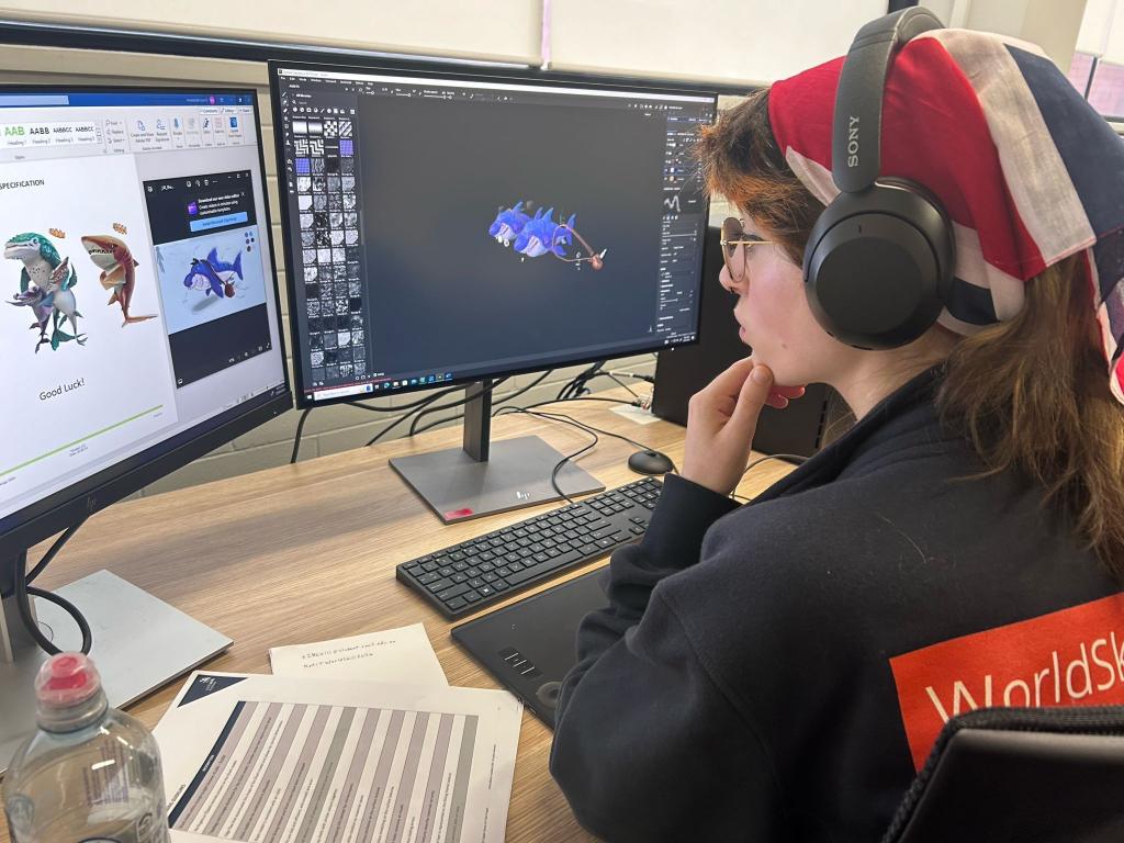 Yasmin sat at a computer designing her characters.