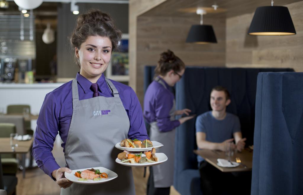 Student serving lunch in Scholars Training Restaurant.