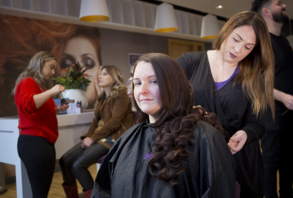 Hairdresser working on a clients hair in a salon.