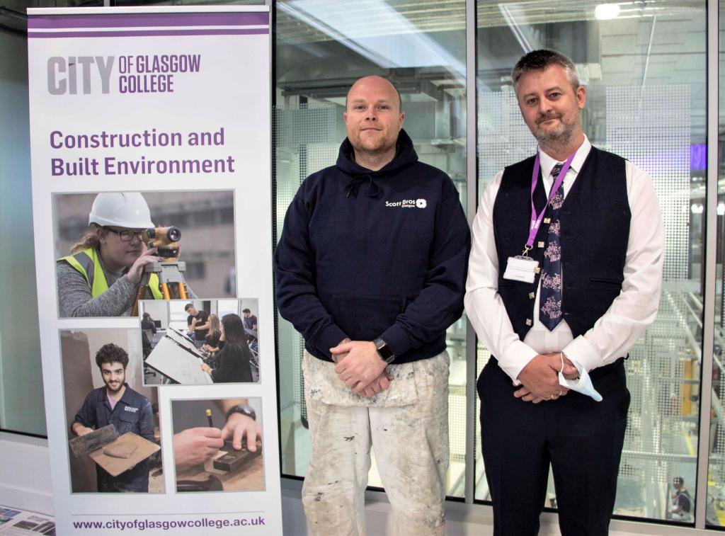 Apprentice Jaemie Smith with Andy McNicol standing next to pop up banner in college