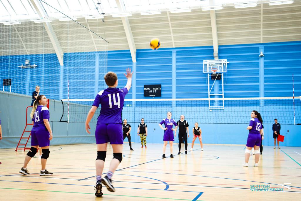 College sports students playing volleyball.