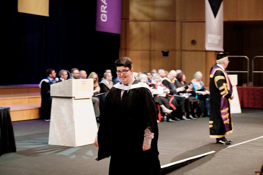 Students walking across the stage at Graduation.