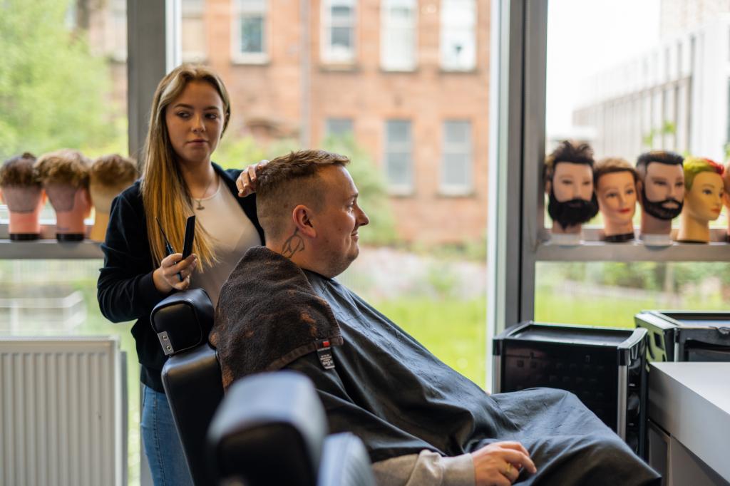 Barbering student cutting clients hair