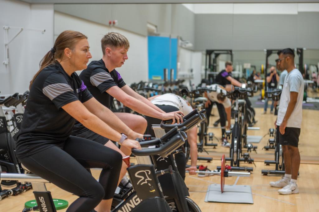 Sports students cycling in the fitness suite