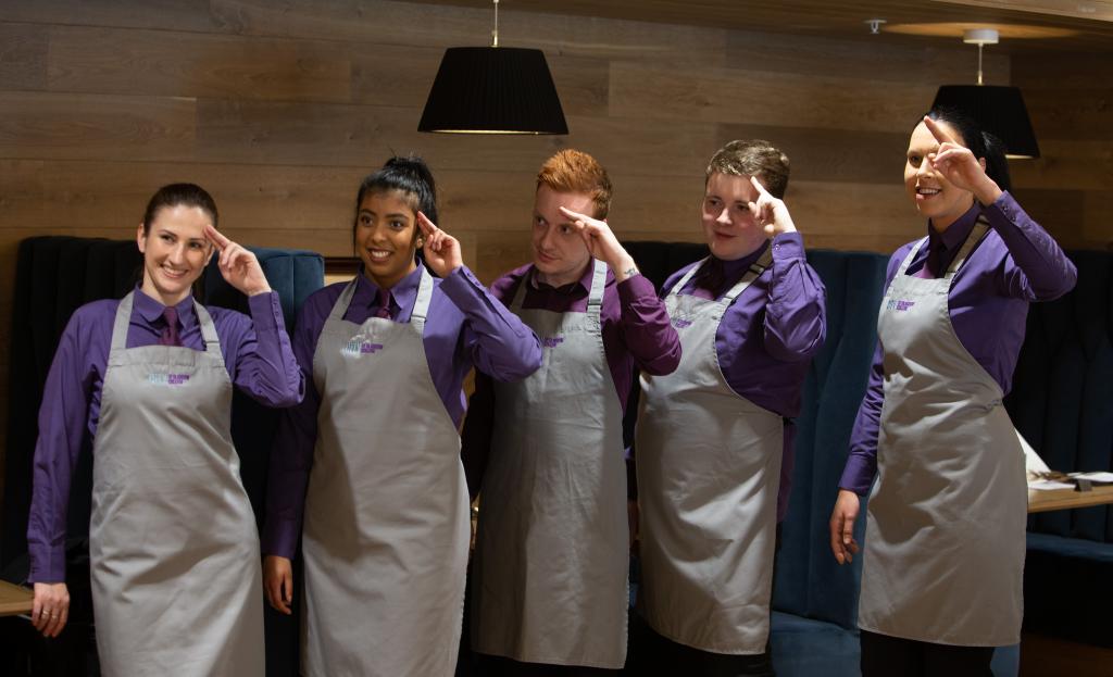 Hospitality students standing in a row at Scholars restaurant.