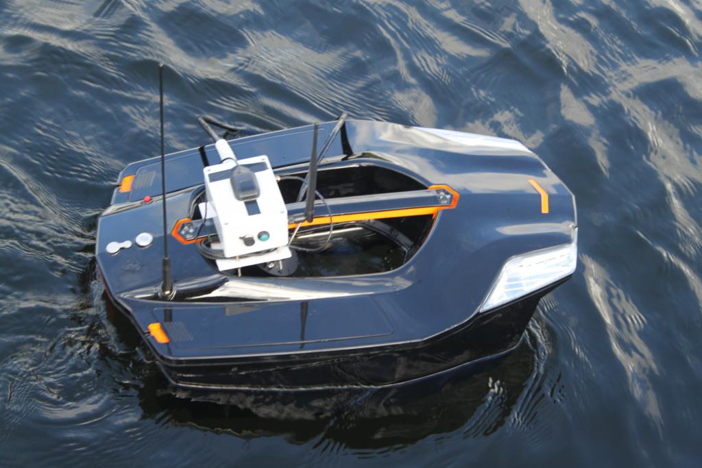 Aquabot, a water quality monitoring platform using digital sensor technology - looks like a small black boat on the water