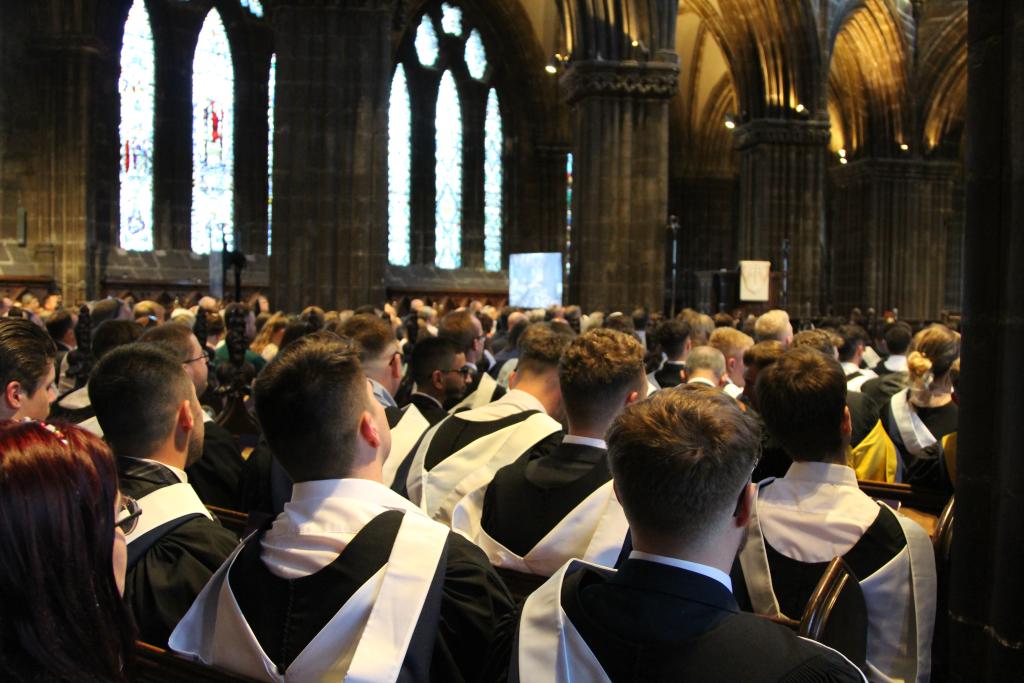 Students sitting in rows in Glasgow Cathedral waiting for graduation to start.