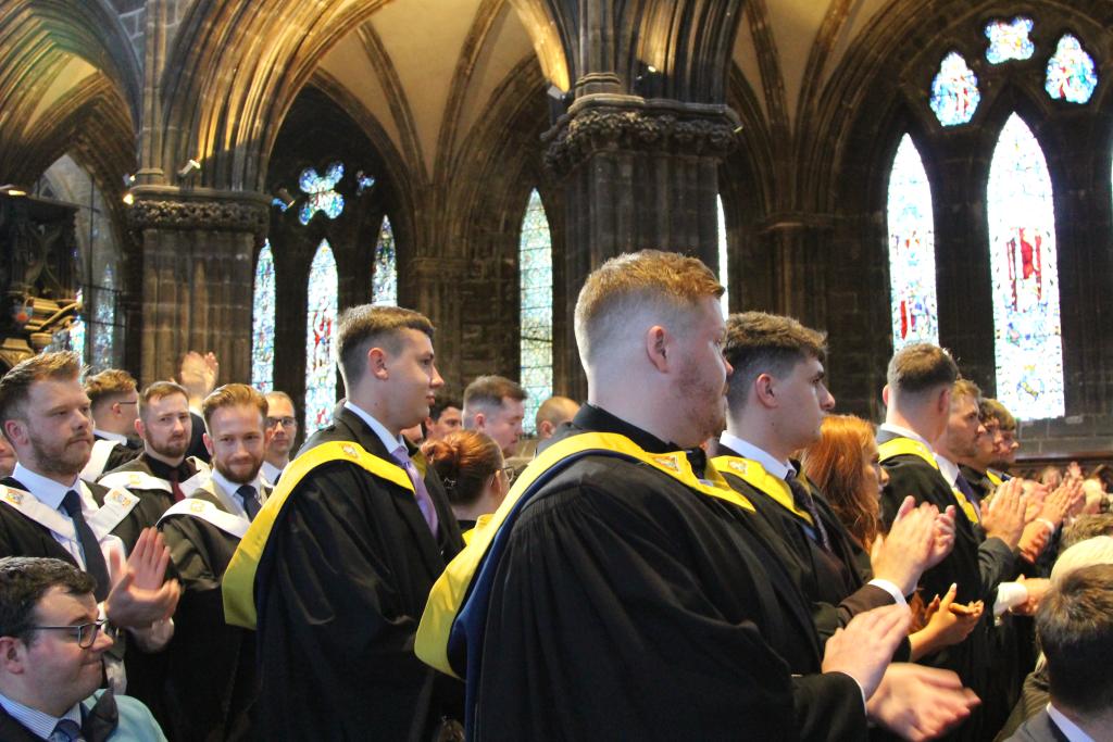 Students sitting in rows in Glasgow Cathedral waiting for graduation to start.