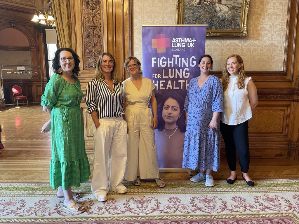 Representatives from the college, Asthma and Lung UK standing in front of an exhibition stand.