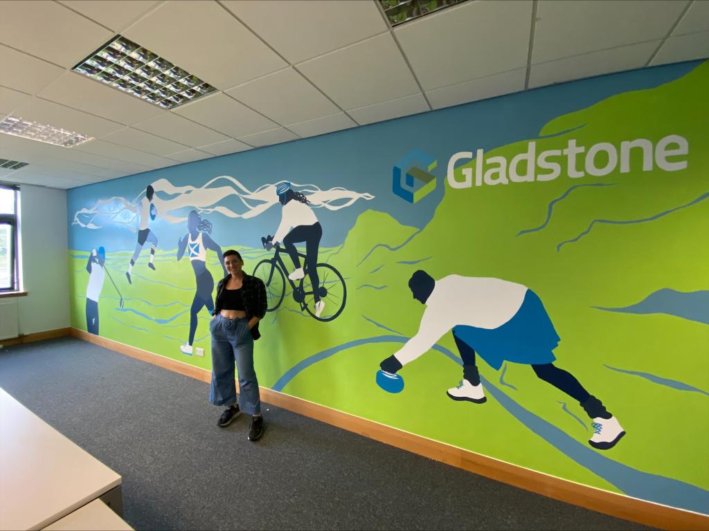 Martina standing in front of her completed mural