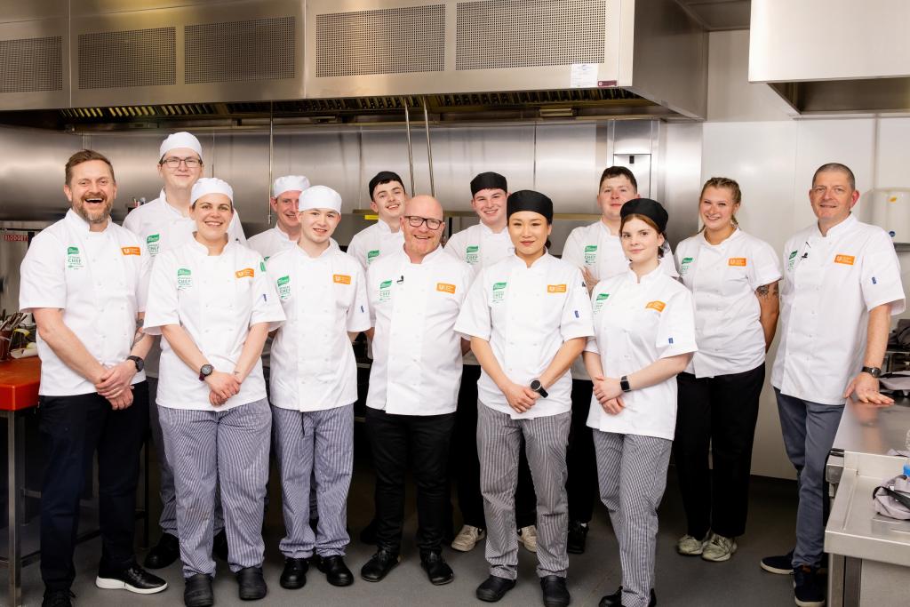 The judges stand with student chef competitors