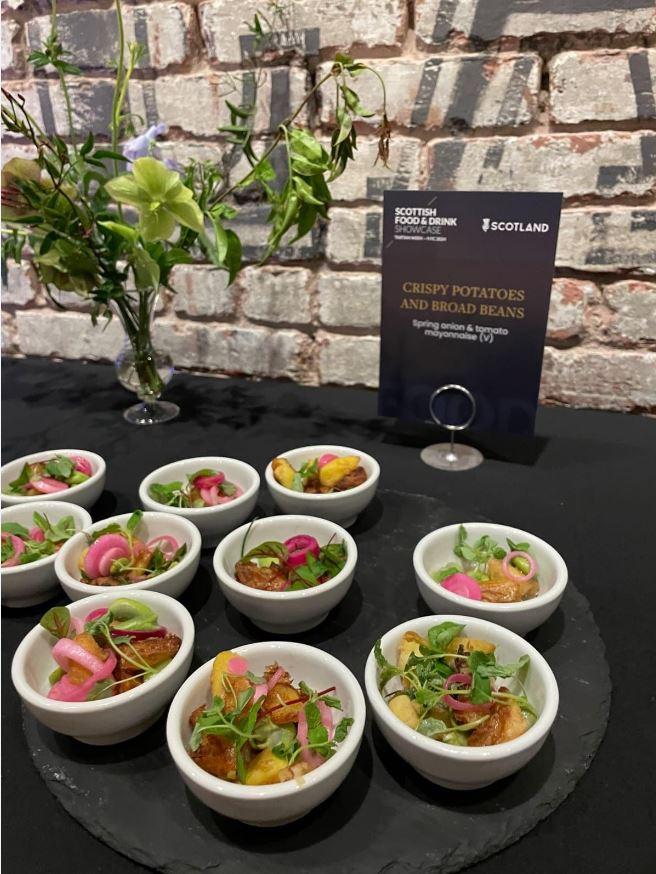 A table with small dishes with Crispy Potatoes and Broad Beans at the Scottish Food and Drink Showcase.