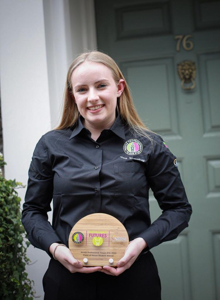 Photo of Tara Humphrey holding her Toque d'Or Front of House winning plaque.