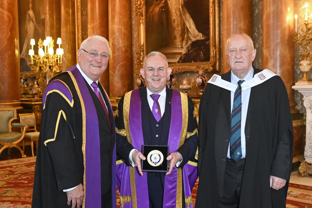 Chair of the Board Alisdair Barron, MBE; Principal Paul Little, CBE and Lead Researcher Daniel C Burke with the QAA Prize.