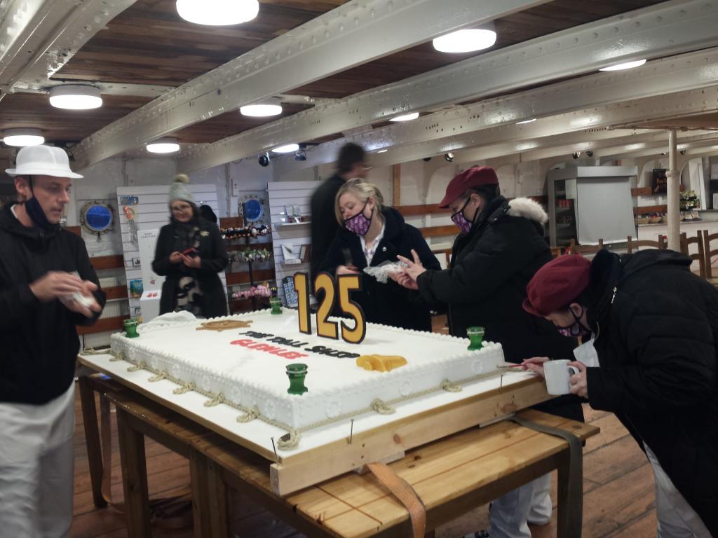 Anniversary cake with students and lecturers on board Tall Ship Glenlee