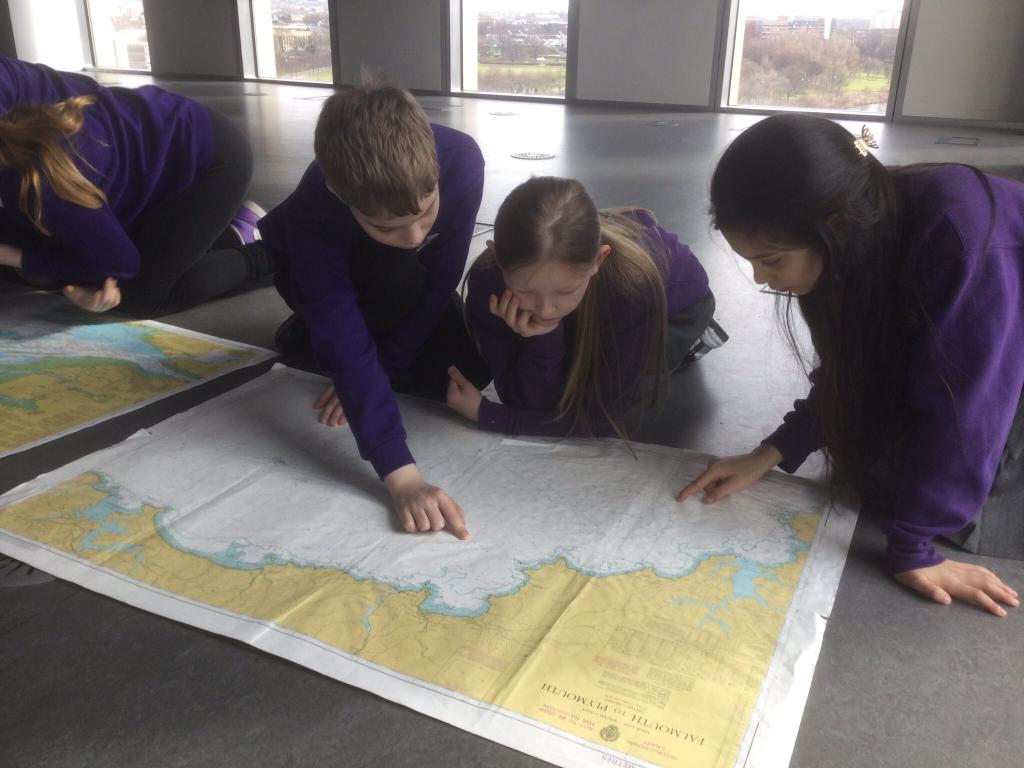 A group of primary school students read a map.