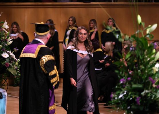 Graduate crossing the stage at graduation.