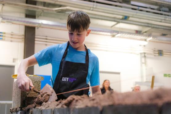 A pupil practices bricklaying 