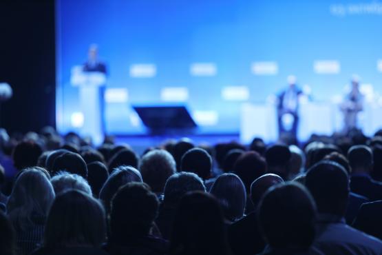 a view from behind of an audience at a conference