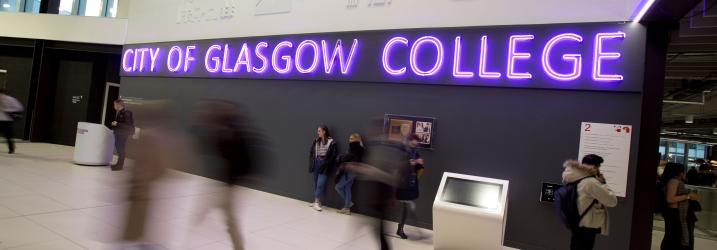 City campus reception area with purple neon sign 'City of Glasgow College'