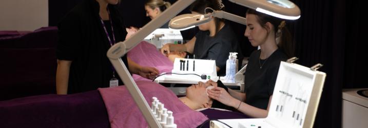 Beauty at Amethyst Training Rooms - A person receiving a relaxing facial from a trainee, with the trainer watching closely.