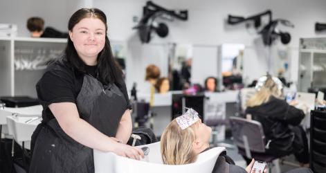 Student in the training salon washing a clients hair