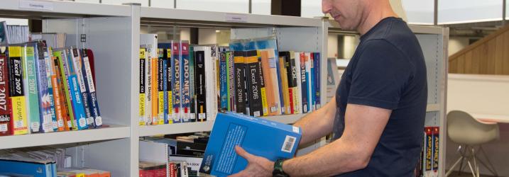 Student browsing books in Library at City campus. Student browsing books in Library at City campus.