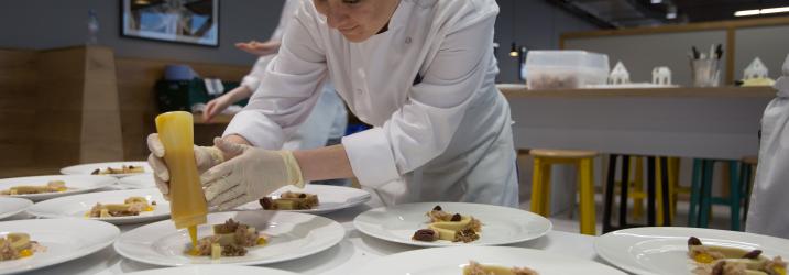 Professional Cookery student preparing plate for service 