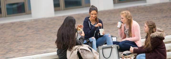 Students drinking coffee in the courtyard at Riverside campus.