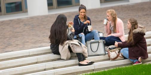 FinTech students drinking coffee in the courtyard at Riverside campus.