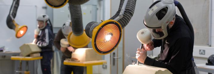 Stonemasonry students working with stones in the college workshops.