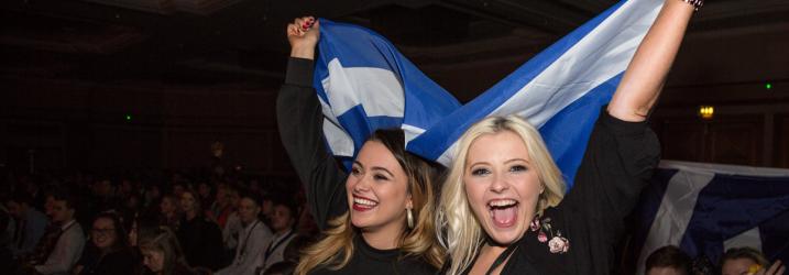 Two women holding up scotland flag at WorldSkills competition