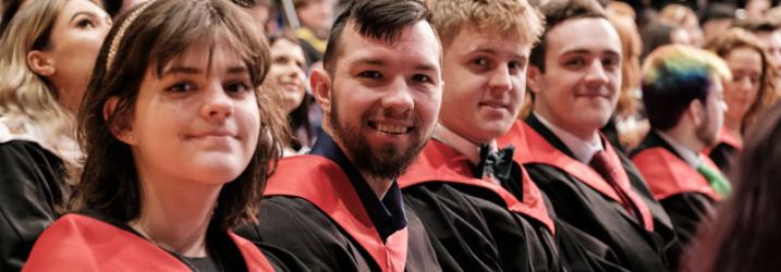 A close up of a row of students in graduation gowns at a graduation ceremony.
